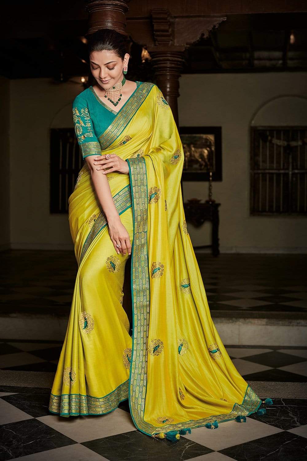 Nalli - Nandhini looks stunning in our bright yellow silk saree with  checked design enclosing intricately woven elephant motifs. The saree is  enriched with a zari border and a scintillating pink pallu